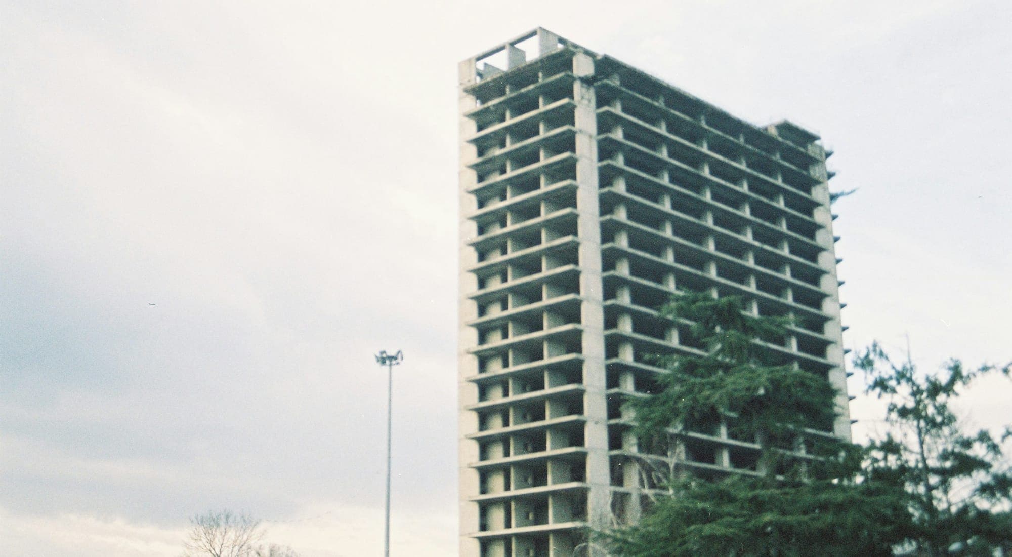 An unfinished concrete tower standing against an overcast sky